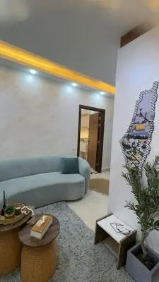 a living room with a blue couch and a table at شقق-روف للايجار اليومي والاسبوعي in Al Qarţū‘īyah