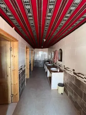 a large bathroom with a red ceiling and two sinks at Mountain Stars Camp in Wadi Rum
