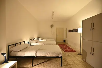 two beds in a white room with a kitchen at AL Majd hostel in Amman