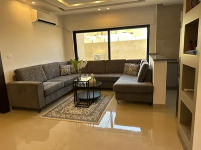 a living room with a couch and a table at 3 Bedrooms Flat in Rabwat Abdoun in Amman