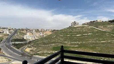 a view of a hill with a road on it at 3 Bedrooms Flat in Rabwat Abdoun in Amman
