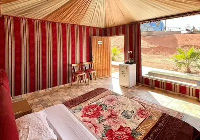 a bedroom with a large bed in a room with a window at Isabella Luxury Wadi Rum in Wadi Rum