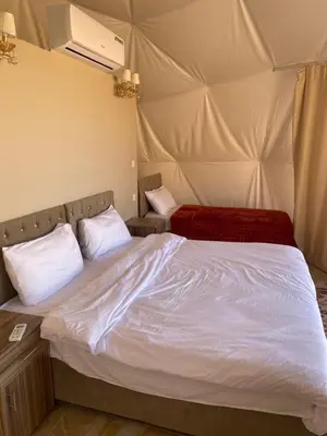 a bed in a room with a tent at Aurora Luxury Wadi Rum in Wadi Rum