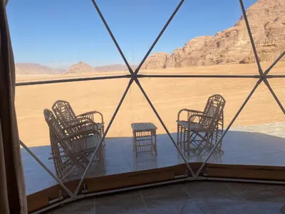 a room with chairs and a view of the desert at Aurora Luxury Wadi Rum in Wadi Rum