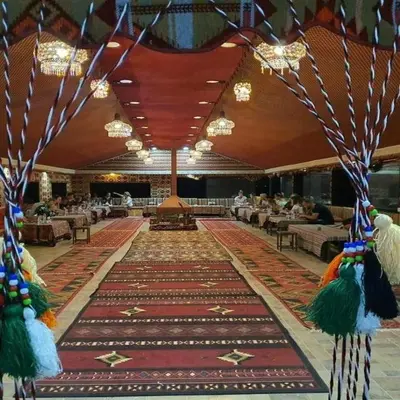 a banquet hall with a large rug on the floor at Super Delxue Tent in Azraq ash Shīshān