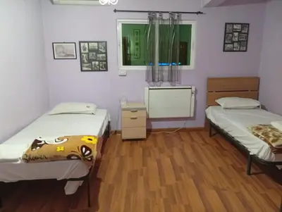two beds in a room with wooden floors at Monastery in Wadi Musa