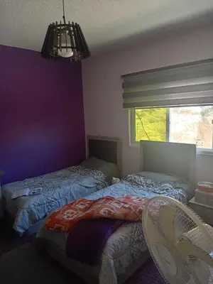 a bedroom with two beds and a window at Sky apartment in Amman