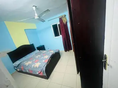 a bedroom with a bed and a ceiling fan at Sky apartment in Amman