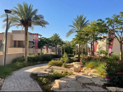 a garden with palm trees and a walkway at قرية الراحة باطلالة بحرية-مرسى زايد-Alraha village -marsa zayed- with sea view in Aqaba