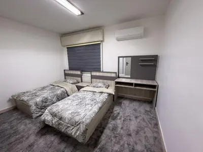 a room with two beds and a dresser in it at 2BR Apartment in Tlaa Al Ali, Parking, AC, WIFI in Amman