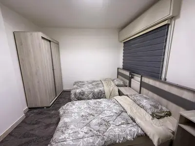 a bedroom with two beds and a window at 2BR Apartment in Tlaa Al Ali, Parking, AC, WIFI in Amman