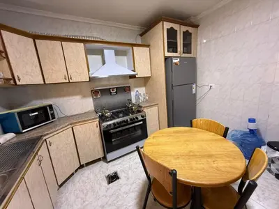 a kitchen with a wooden table and a kitchen with a stove at 2BR Apartment in Tlaa Al Ali, Parking, AC, WIFI in Amman