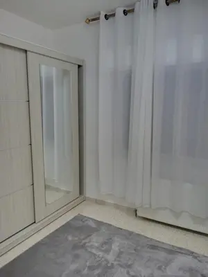 a room with a window and a curtain at Two-Bedroom Apartment in Swefieh in Amman