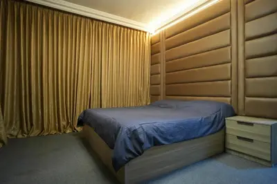 a bedroom with a bed in a room with curtains at الوجيه للشقق الفندقية in Amman