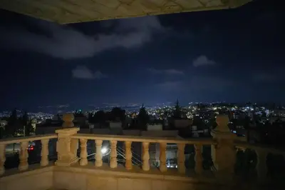 a view of a city at night from a balcony at الوجيه للشقق الفندقية in Amman