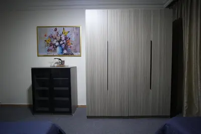 a bedroom with a cabinet with a sink and a painting at الوجيه للشقق الفندقية in Amman