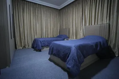 a hotel room with two beds with blue sheets at الوجيه للشقق الفندقية in Amman