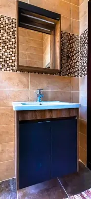 a bathroom with a blue sink and a mirror at Private Chalet in Dabouq , Night-Lit in Amman