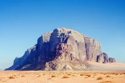 a large rocky mountain in the desert on a clear day at Moon light in Disah