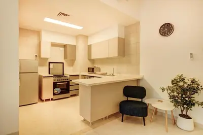 a kitchen with a counter and a chair in it at Al-Raha Luxury apartment in Aqaba