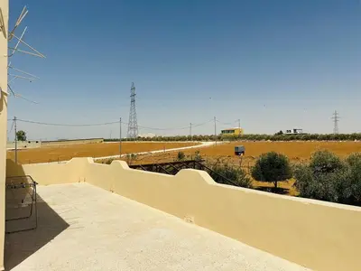 a wall with a view of a field and a farm at شقة واسعة وهادئة in Umm Juraysāt