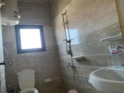 a bathroom with a toilet and a sink and a window at Jorh BB in Amman
