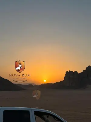 a car parked in front of a sunset in the desert at Nova Rum Luxury Camp in Disah