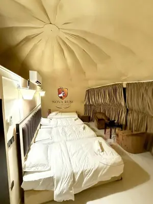 a large white bed in a room with a ceiling at Nova Rum Luxury Camp in Disah