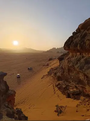 a view of a beach with the sun setting at Bright Moon Luxury Camp in Wadi Rum