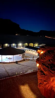 a beach at night with a bridge and lights at Bright Moon Luxury Camp in Wadi Rum