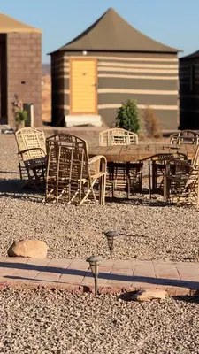 a group of chairs and a picnic table in a yard at Bright Moon Luxury Camp in Wadi Rum
