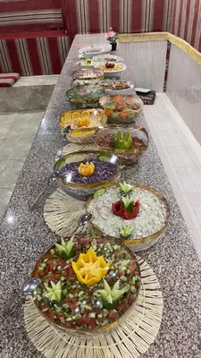 a long table with many plates of food on it at Bright Moon Luxury Camp in Wadi Rum