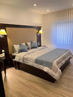 a bedroom with a large bed and a desk at Luxurious 2 bedroom furnished apartment in Abdoun in Amman