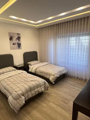 a bedroom with two beds and a window at Luxurious 2 bedroom furnished apartment in Abdoun in Amman
