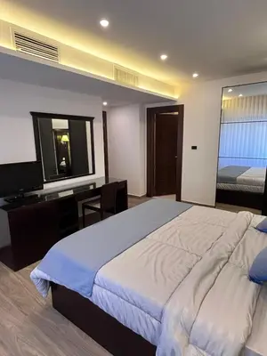 a bedroom with a bed and a desk and a television at Luxurious 2 bedroom furnished apartment in Abdoun in Amman