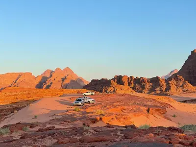 two vehicles parked on a dirt road in the desert at Red Dunes Wadi Rum Camp in Wadi Rum