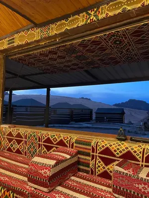 a room with a table and two chairs and mountains at Red Dunes Wadi Rum Camp in Wadi Rum