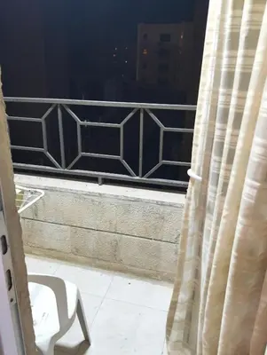 a chair sitting on a balcony looking out of a window at عمان in Amman