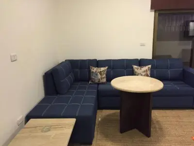 a living room with a blue couch and a table at Ammoun Luxury Apartments 1 in Amman