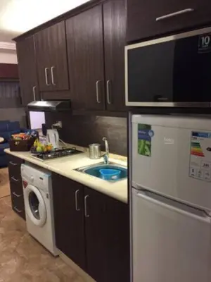 a kitchen with a sink and a stove and a refrigerator at Ammoun Luxury Apartments 1 in Amman