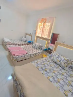 a room with three beds and a mirror at Sama rjan in Irbid