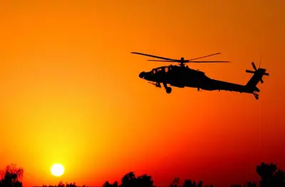 a helicopter flying in front of the sunset at Ramses luxury rum camp in Wadi Rum