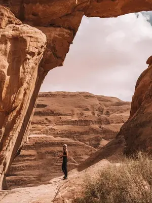a woman standing in a cave in the desert at Fahd Camp Wadi Rum in Wadi Rum