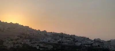 a city on top of a hill at sunset at Petra Breeze in Wadi Musa