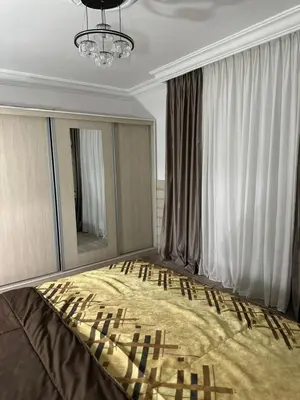 a bedroom with a large bed with a chandelier at Super deluxe apartment in Irbid
