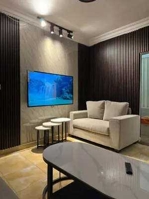a living room with a couch and a tv on a wall at Super deluxe apartment in Irbid