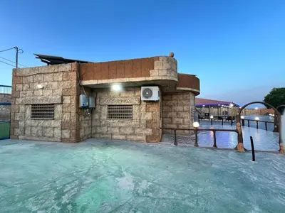a large swimming pool with a stone building at مزرعة وشاليه ادم