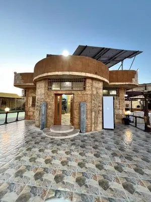 a large stone building with a clock on it at مزرعة وشاليه ادم