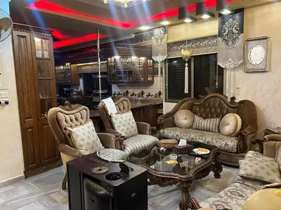 a living room with two chairs and a table at No Stars in ‘Urjān al Gharbīyah