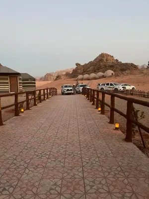 a group of cars parked on a road in the desert at Sand Desert Camp in Wadi Rum